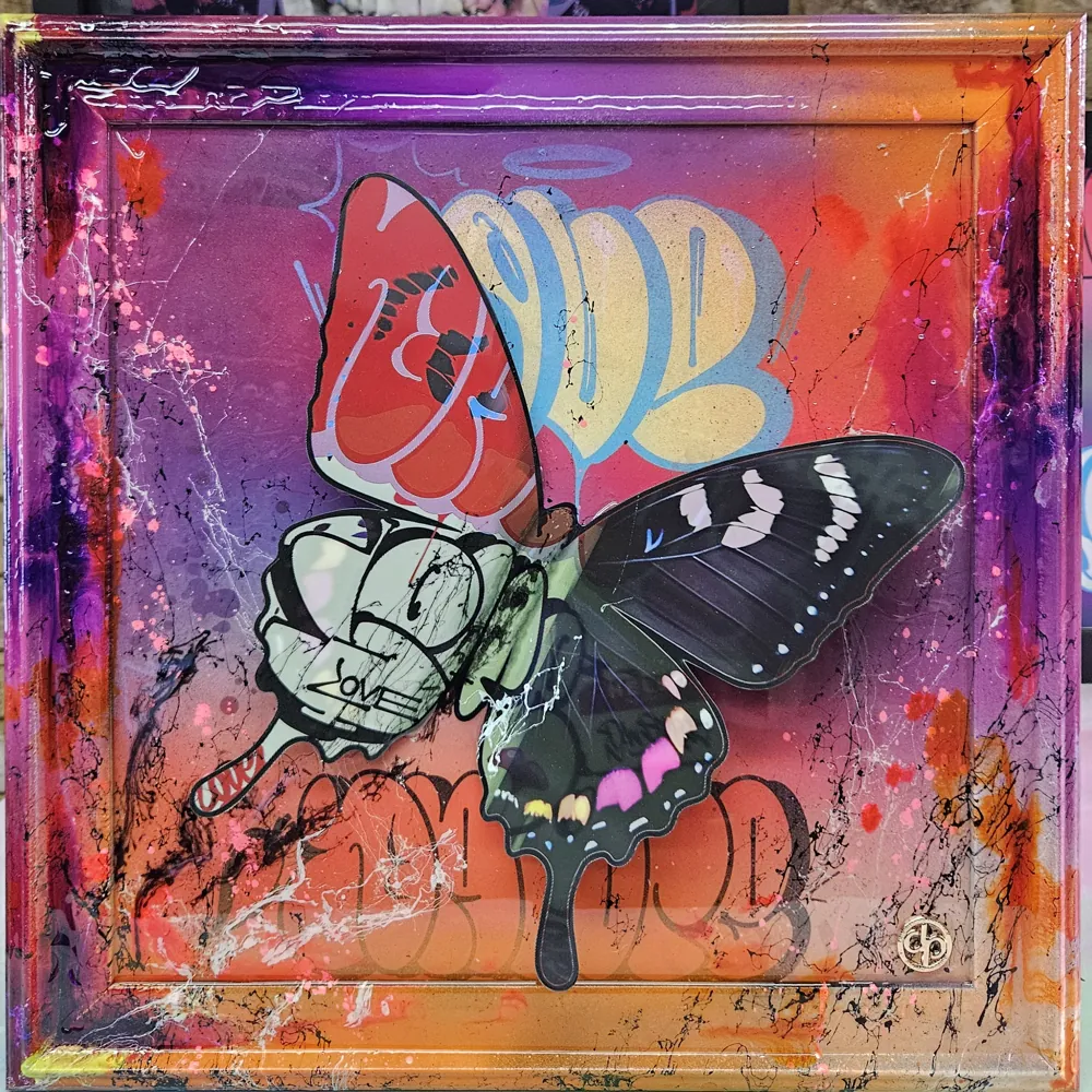 Framed mixed-media butterfly on a spray-painted purple to orange ground