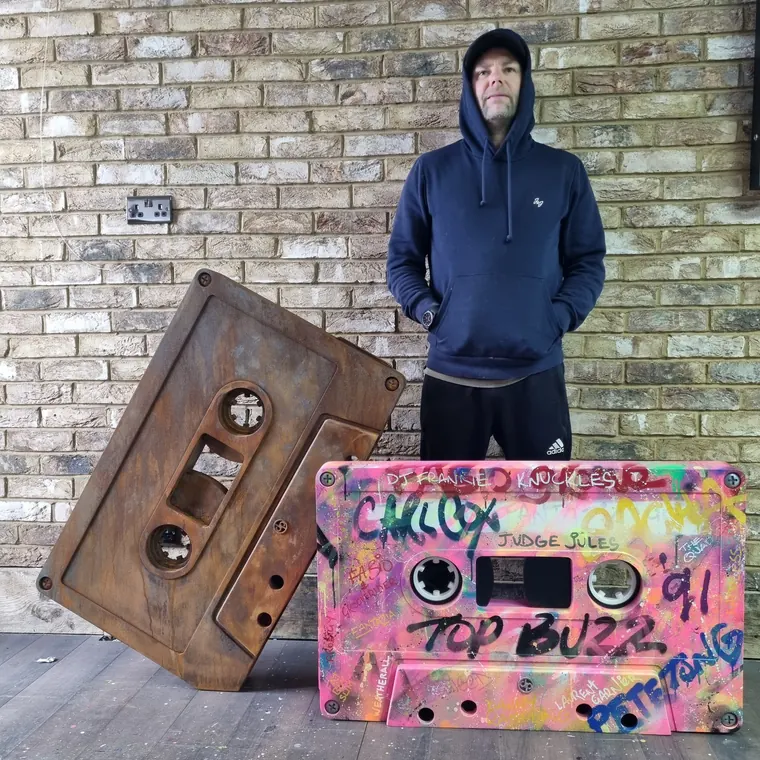 Dan Pearce with two oversized cassette sculptures, one rusted steel and one spray-painted